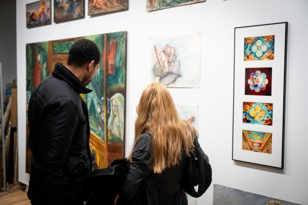 Two visitors are engaged in observing Sybil Goldstein's exhibition